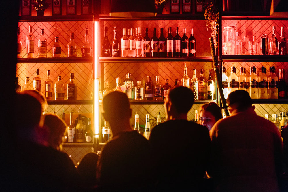 A group of people gathered at a neon lit bar